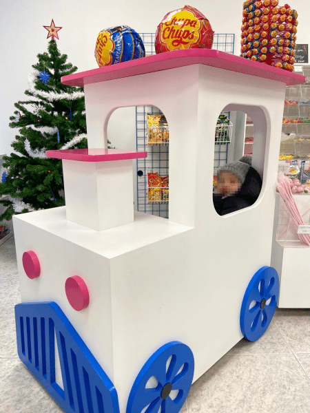 Isla central con diseño de locomotora para tiendas de golosinas y comercios infantiles.