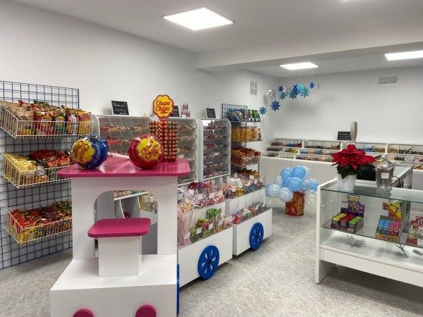 Isla central en forma de tren con compartimentos de metacrilato para exhibición de golosinas.
