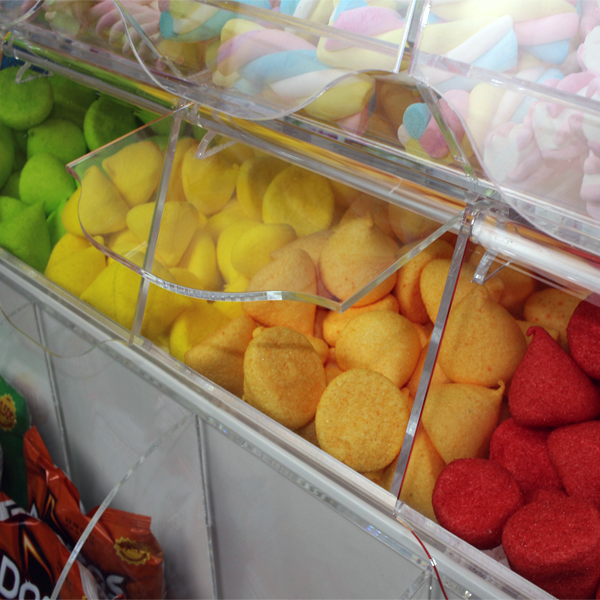 Isla central con carameleras y recipientes transparentes para golosinas y snacks.